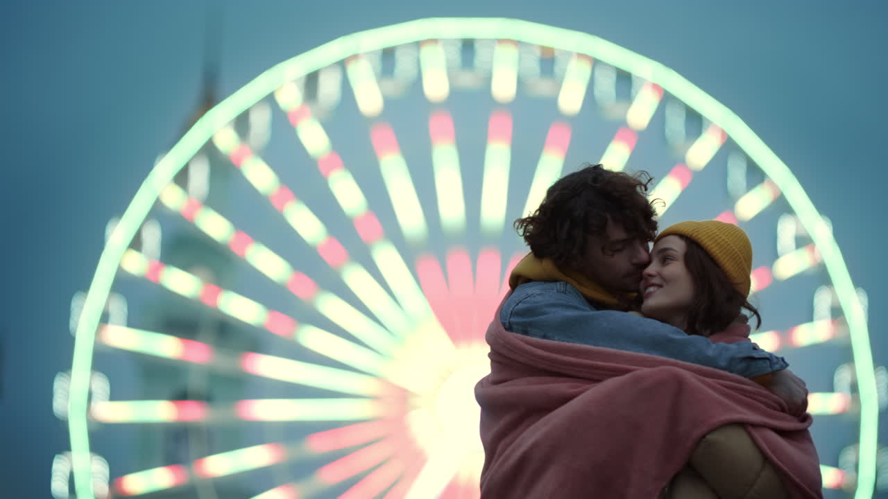 мужчина, покрывающий женщину одеялом.