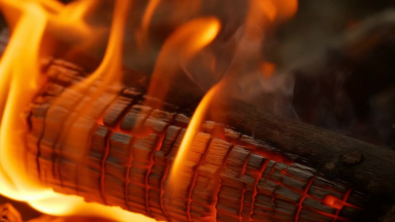 Guarda come fiamme arancioni e rosse vibranti bruciano intensamente in un accogliente camino, circondato da legna e cenere, creando un'atmosfera calda e drammatica. Questo primo piano cattura i colori vividi
