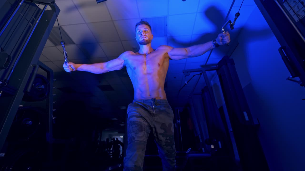 Exercise for triceps in the gym. Training of muscular man in the gym