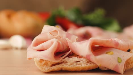 preparing a ham and salami sandwich