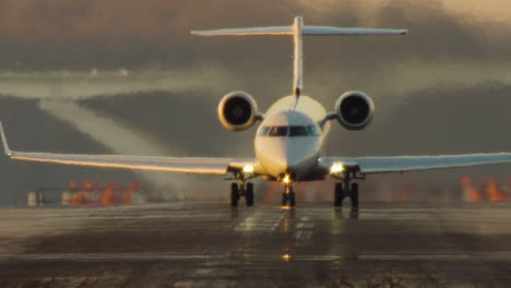 small jet lifts off from runway at sunset