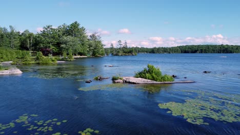 forward and low over tiny rock island on big bald lake in cottage country trent, ontario