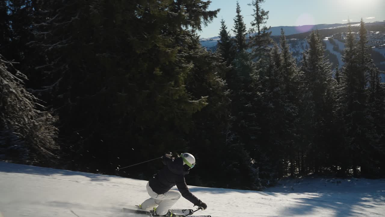 4k slowmotion слежение за женщиной на лыжах и карвингом во время скоростного спуска по трассе в солнечный зимний день в норвегии