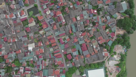 aerial view of densely packed residential neighborhood by a river in hanoi, vietnam