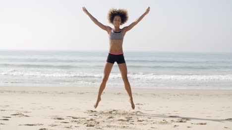 fit woman jumping on the beach