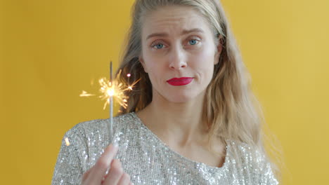 woman holding sparkler with a disappointed expression