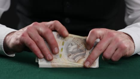 man counting polish zloty on table . a man in a business shirt is counting polish mon. man hands count polish banknotes