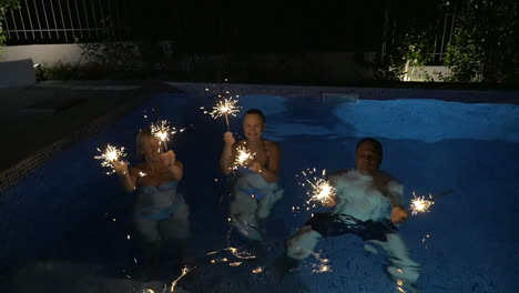 family or friends with bengal lights in the pool