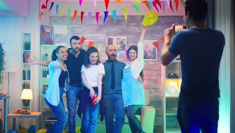 young man at a party taking photos of his friends