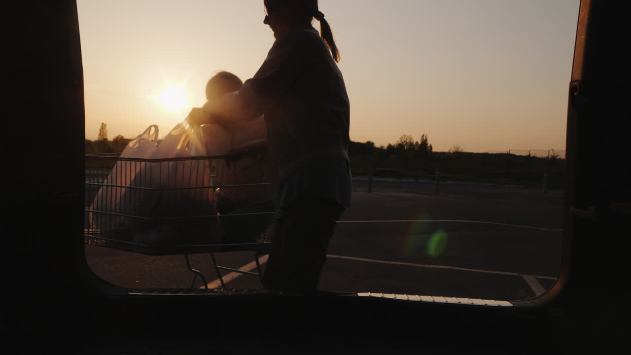 la familia pone bolsas de compras del supermercado en el maletero del coche