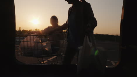 Familia-Pone-Bolsas-De-Compras-Del-Supermercado-En-El-Maletero-Del-Coche