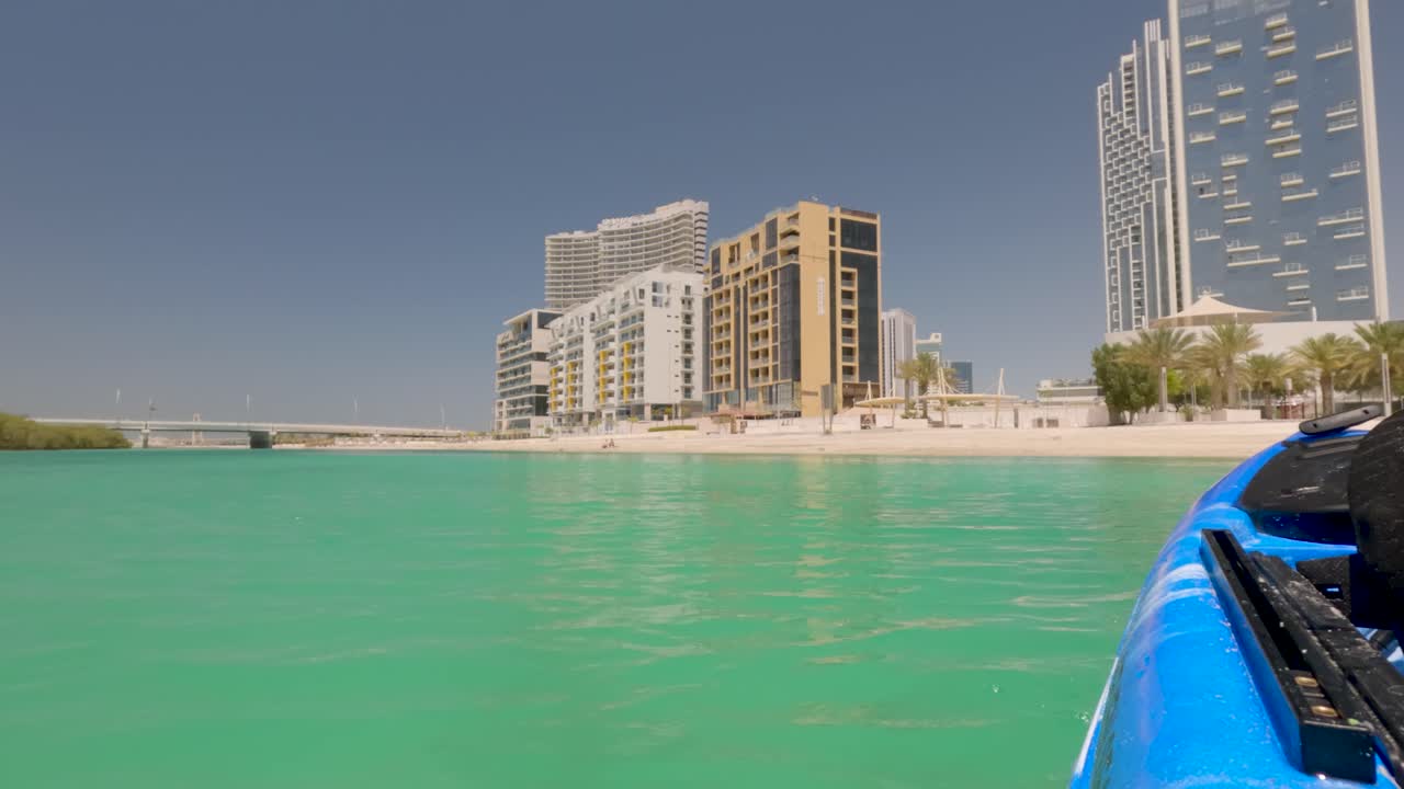 Panoramic view of Abu Dhabi's Al Reem Island's city skyline from a kayak along the beach on a sunny day in the United Arab Emirates