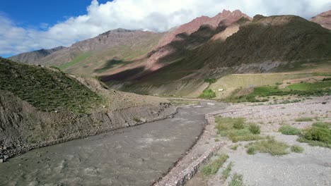 dry-riverbanks-of-pin-valley-on-a-sunny-morning-with-gray-river-flowing-through-the-mountains-in-India,-aerial