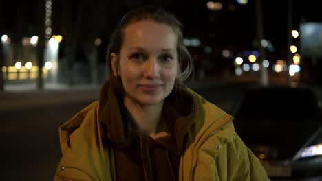 Magníficas-Imágenes-Frontales-De-Una-Mujer-Joven-Naturalmente-Hermosa-Con-Cabello-Rubio-Parada-En-La-Calle-Y-Sonriendo.-Noche