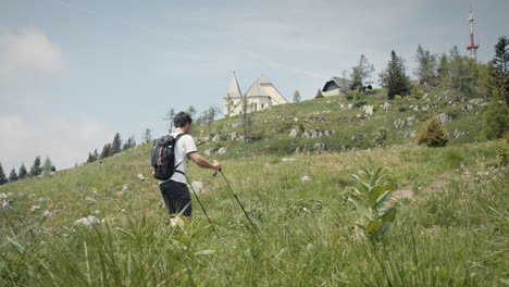 young hiker walking past the camera on a path towards the top of mountain