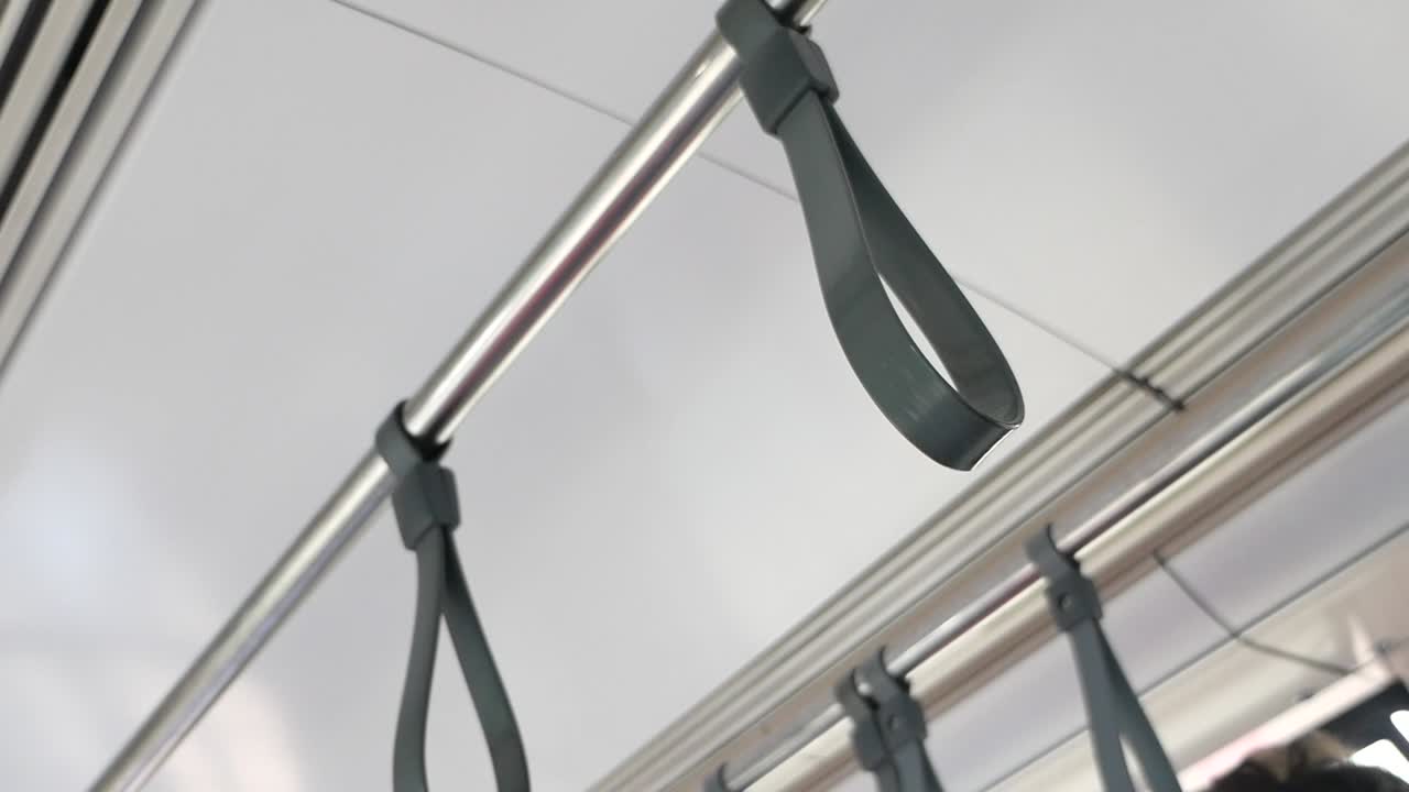 Hand holding onto a bus handle