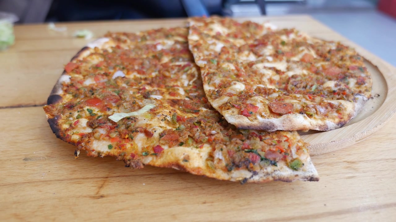 Preparazione di Lahmacun tradizionale turco con limone e lattuga