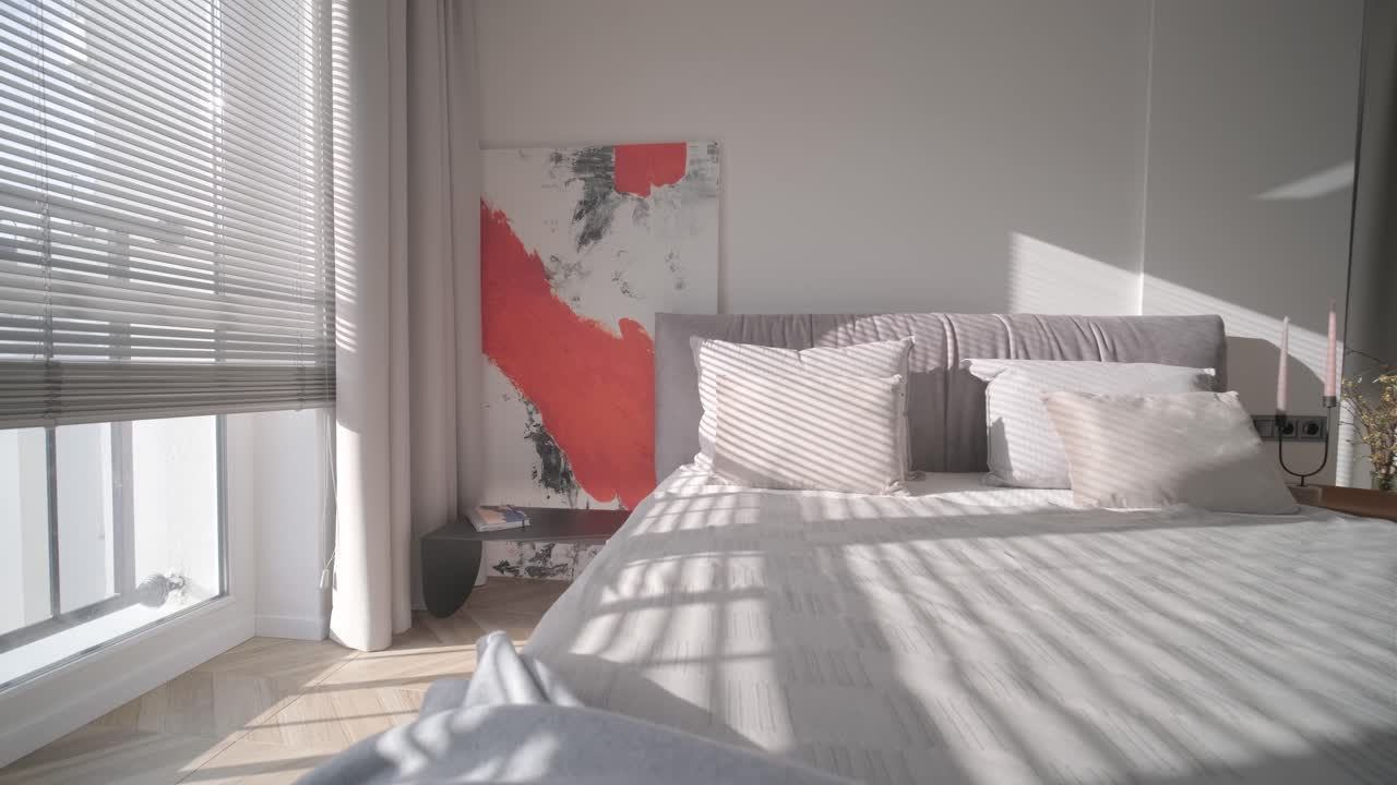 diseño y decoración de interiores de dormitorios modernos con sábanas blancas y grises, silla blanca, cabecera de luz nocturna.