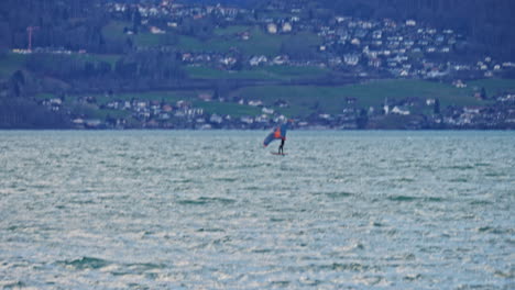 Eine-Aufnahme,-Die-Einem-Mann-Folgt,-Der-Im-Winter-Auf-Einem-See-Foilboard-Fährt