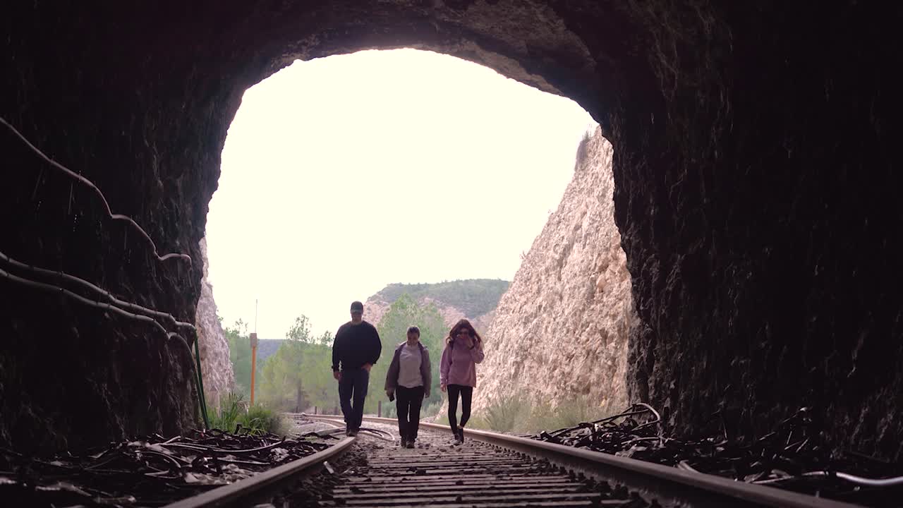 People walking on abandoned railway. Forgotten paths hiker group of backpacker friends. Hiking adventure in nature.