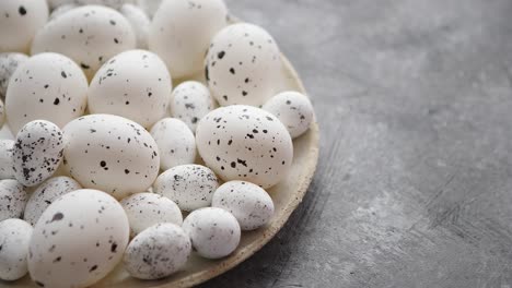 Composition-of-white-traditional-dotted-Pascua-eggs-in-white-ceramic-plate