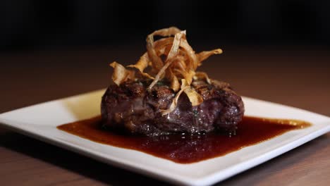 beef tournedos rossini topped with haystack onions and demi-glace sauce