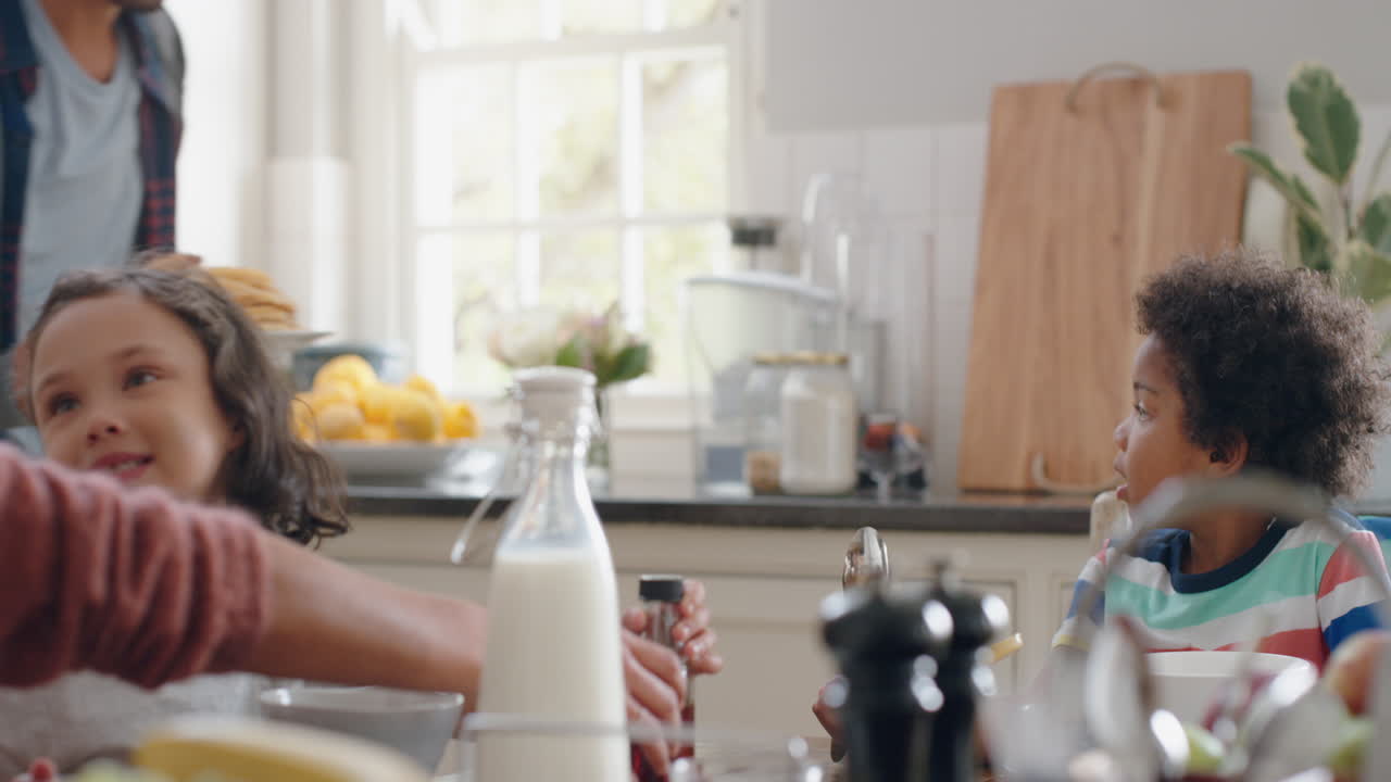 행복 한 가족 이 아침 식사 에 와플 을 먹고 아이 들 과 함께 집 에서 주방 에서 맛있는 맛 을 즐기고 있다