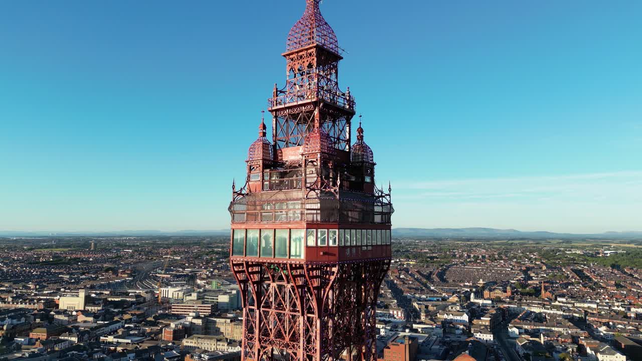 화창한 날 아름다운 스카이라인과 함께 전망대와 조명을 보여주는 블랙풀 타워 꼭대기 주변의 공중 드론 비행