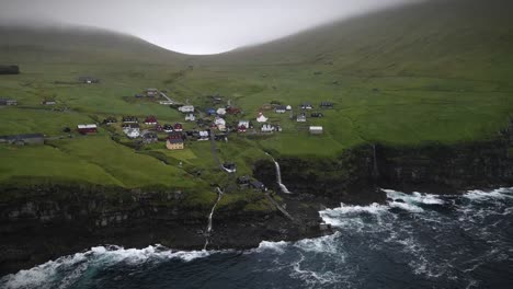 charming village on kalsoy island surrounded by lush green hills, dramatic cliffs, cascading waterfalls, and the vast north atlantic ocean, offering breathtaking views and a peaceful atmosphere