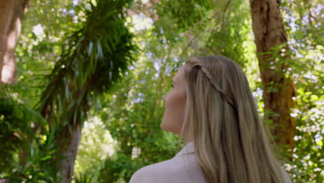 hermosa mujer caminando en el bosque naturaleza chica explorando exuberante jardín encantado por la belleza natural al aire libre 4k