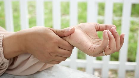 woman checking her wrist for pain