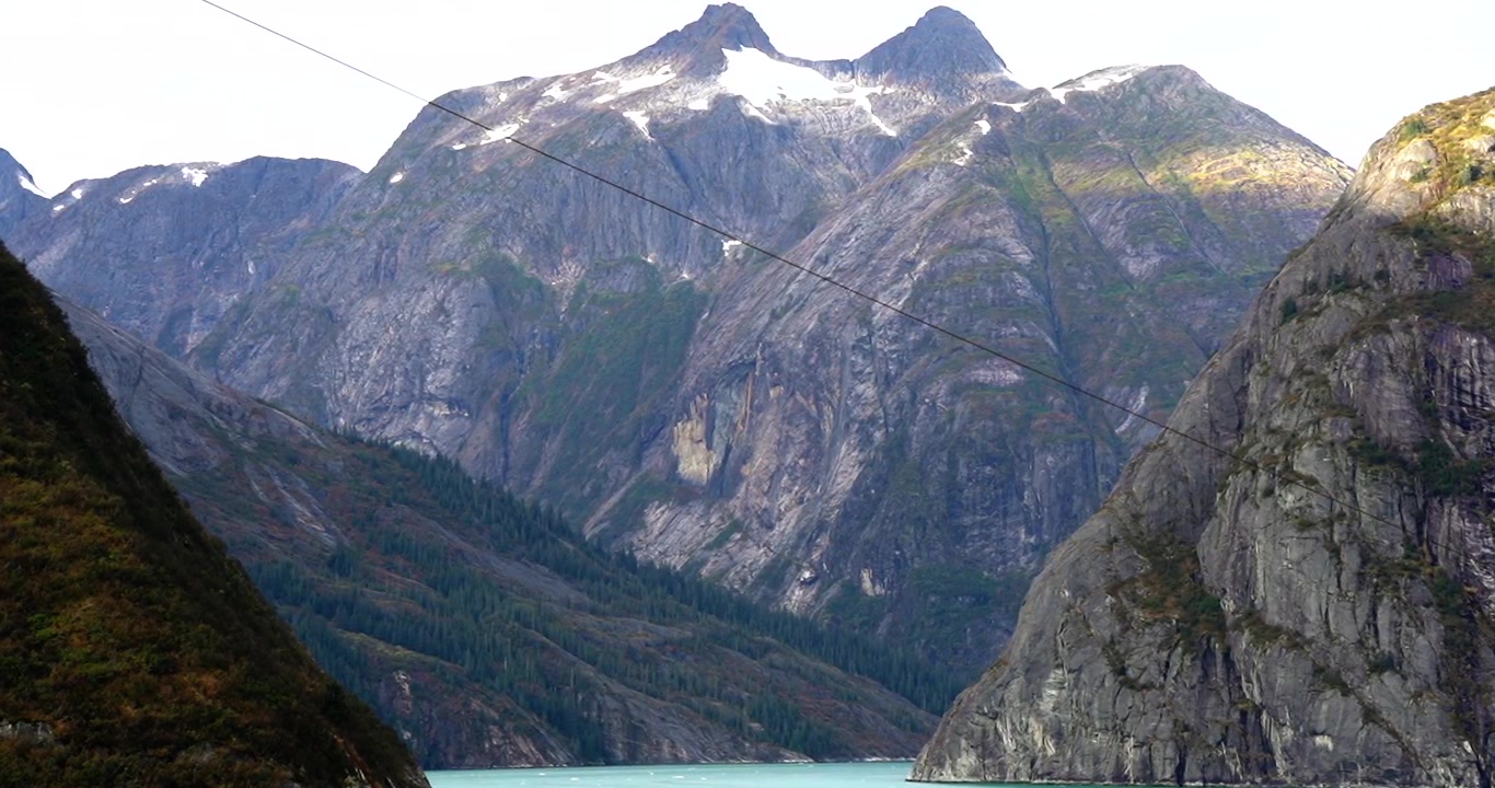 Tracy Arm Fjord, Alaskas bjerge set bagfra et krydstogtskibs ræling.