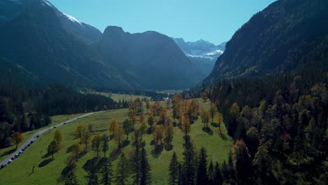 colorful maple trees at ahornboden with red and yellow fall leaves in sunny vibrant autumn in the alps mountains in tyrol, austria with a forest at rissach engtal tourist travel spot