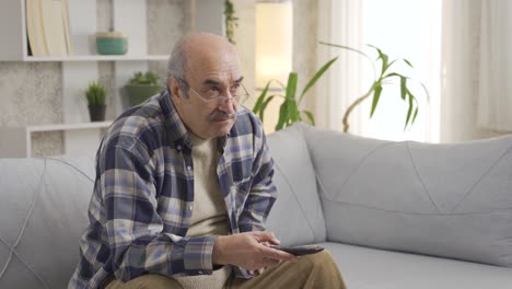 de oude man die tv kijkt wordt boos.