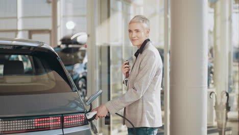 mujer cargando un coche eléctrico