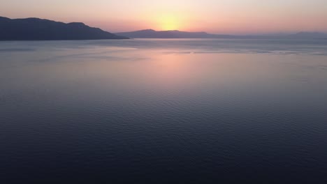 vuelo hacia el amanecer en el horizonte sobre el agua del océano azul claro, imágenes aéreas, inclinado