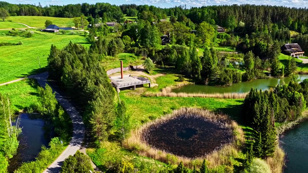 Eine ländliche Landschaft mit einer Holzplattform, umgeben von üppigem Grün und Teichen. Ideal für Naturdokumentationen oder Reiseinhalte.