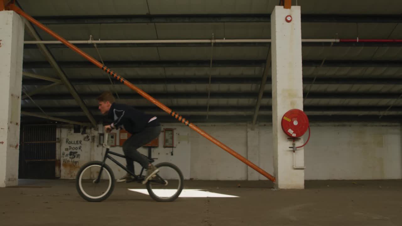 jinete de bmx en un almacén vacío