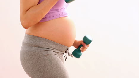 pregnant woman lifting dumbbells