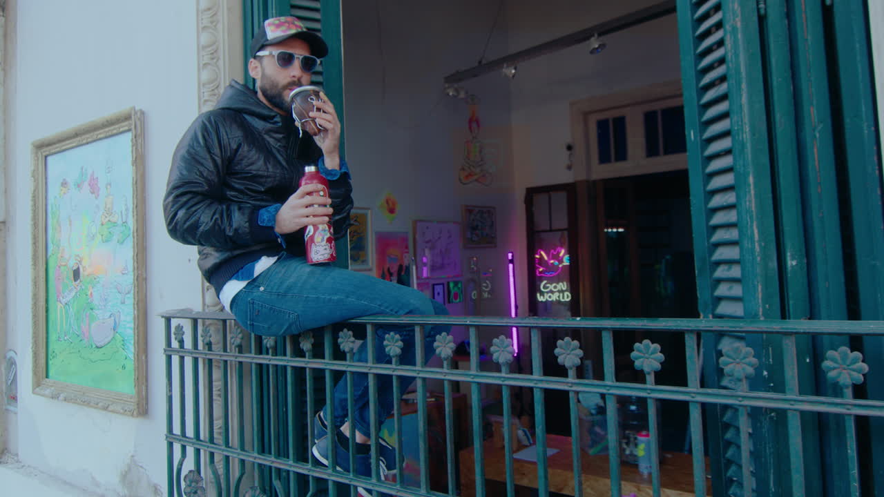 Graffiti Artist Drinking Tea on a Balcony Outside of Creative Studio