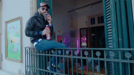 graffiti artist drinking tea on a balcony outside of creative studio