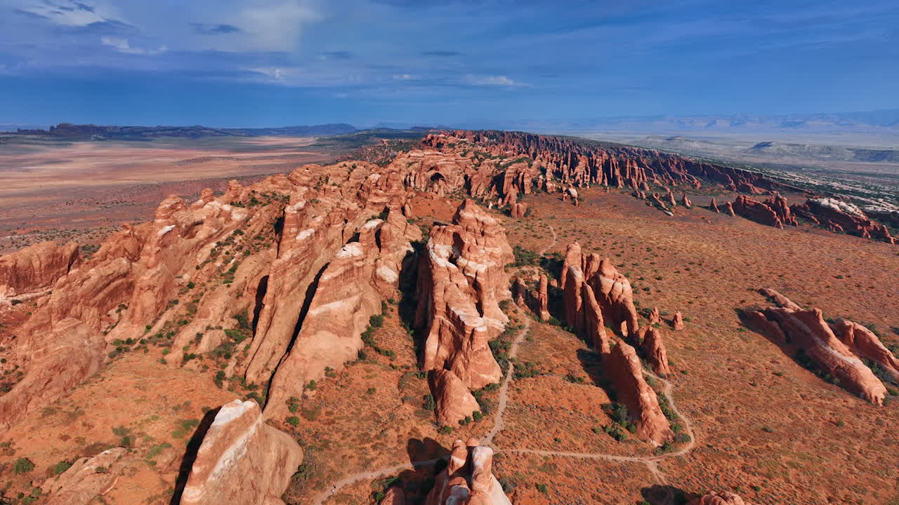 Sorvolo della linea di rocce crestate che si estende nell'arido deserto. Incredibili formazioni rocciose nell'Arches National Park, Utah, USA