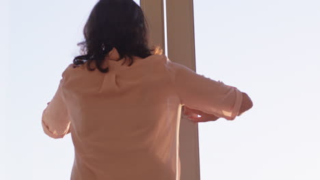 happy couple hugging at home looking out window at sunset enjoying successful retirement lifestyle on vacation sharing romantic connection