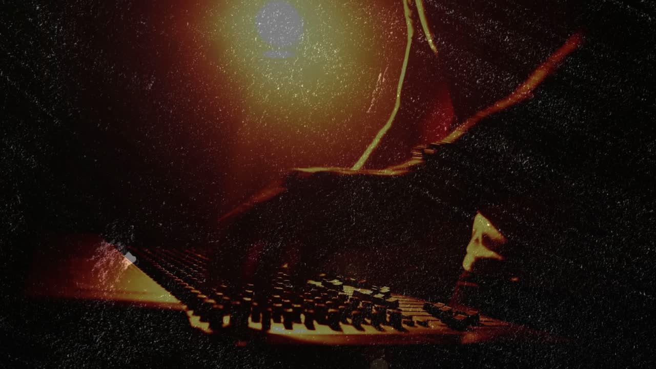 Male musician leaning in and manipulating faders, knobs, pads while shaping live electronic mix