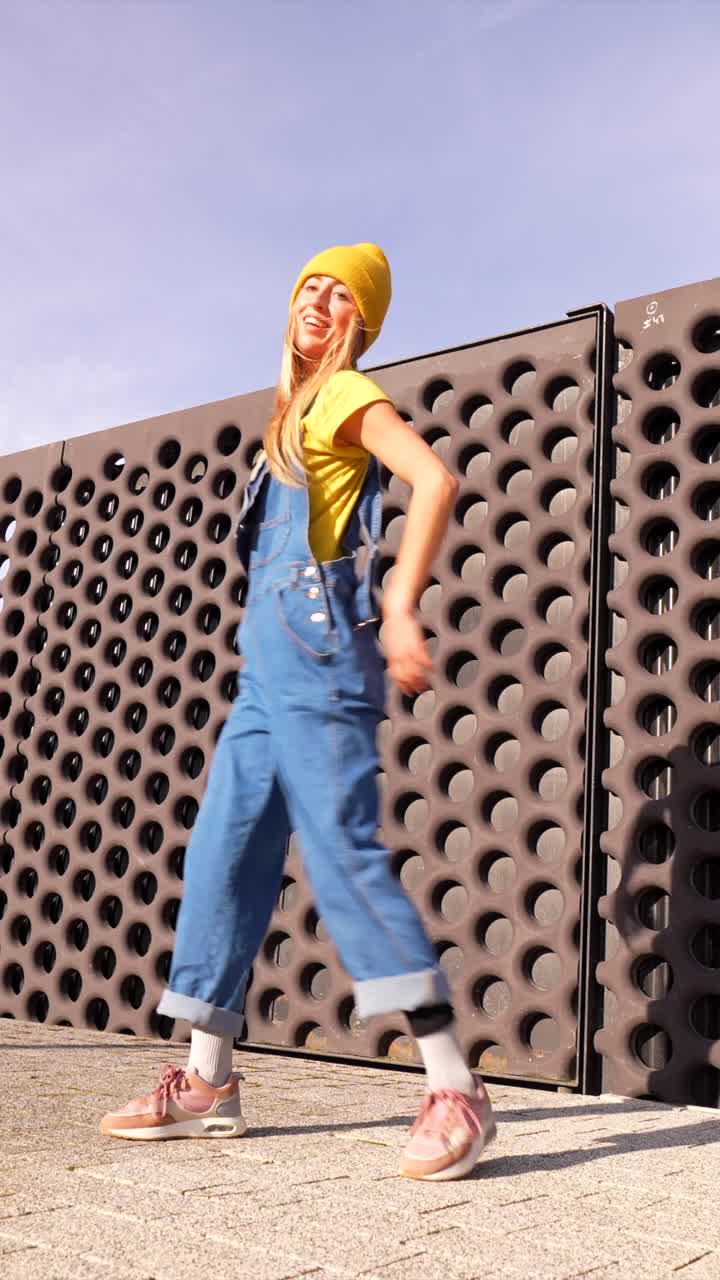 Woman Dancing in Overalls and Yellow Beanie