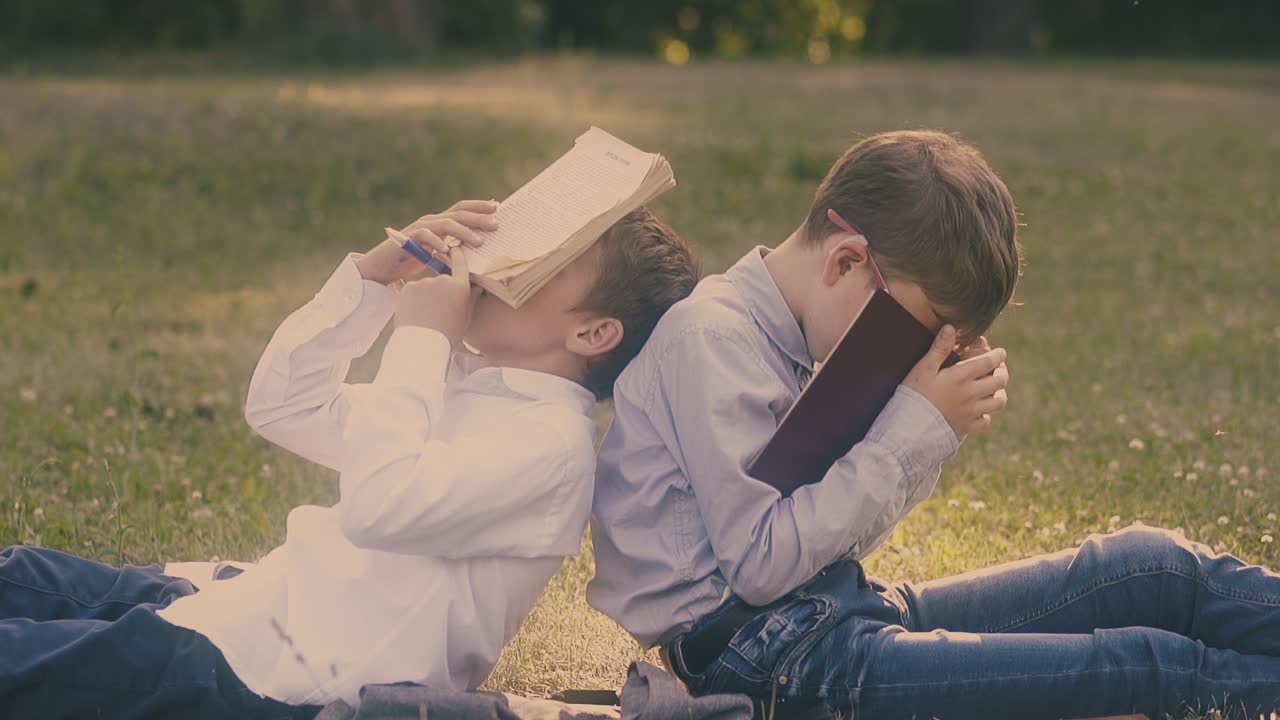 셔츠 를 입은 젊은 남자 들 은 정원 1 에서 손 에 책 을 들고 잠 을 자고 있다