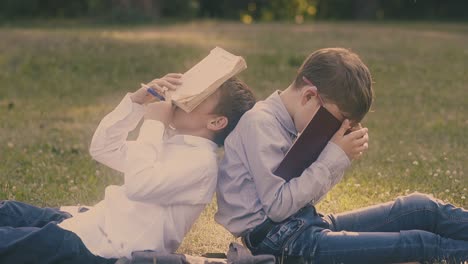 young guys in shirts sleep with books in hands in garden 1