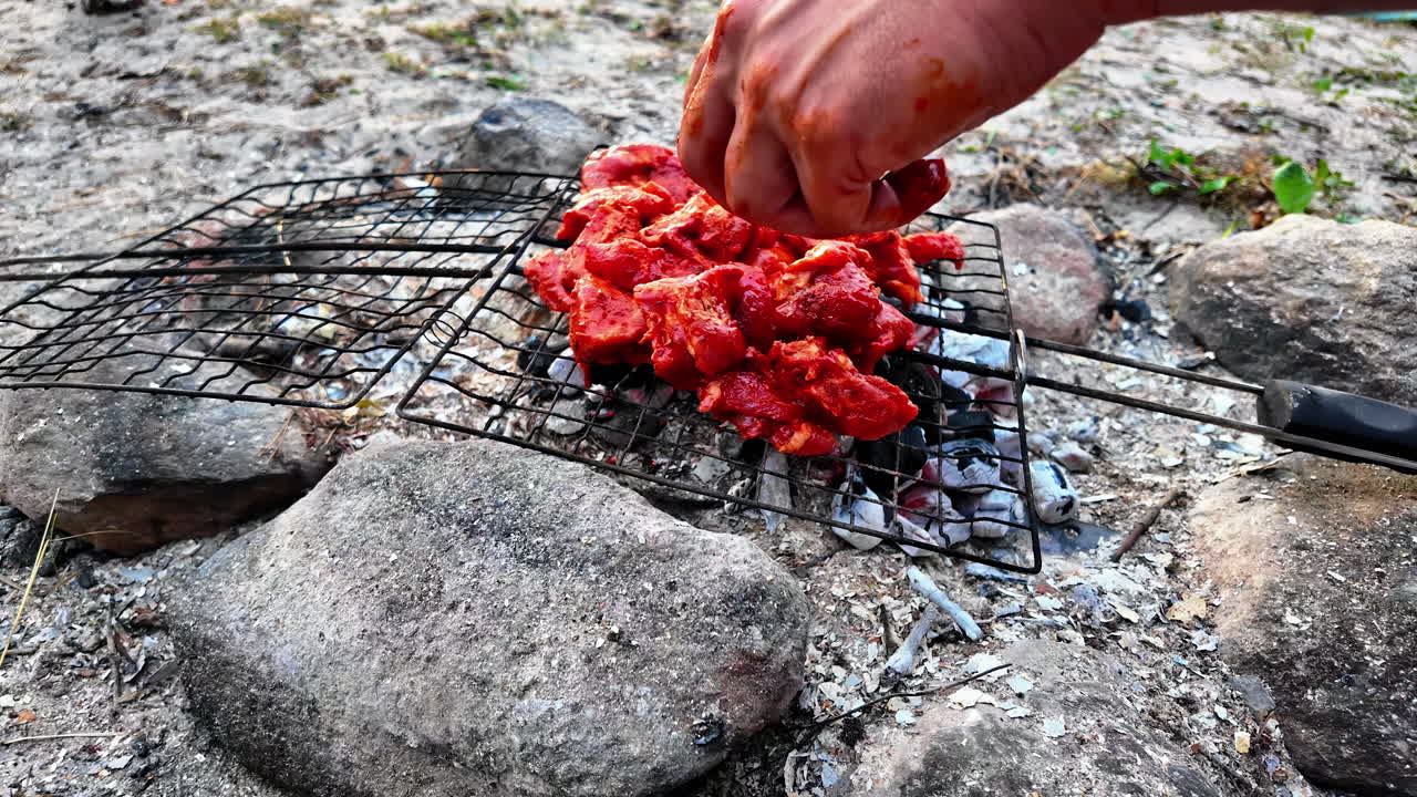 남자 손은 그릴에 고기를 놓고 모래에서 해변에 bbq, 느린 동작으로 클로즈업