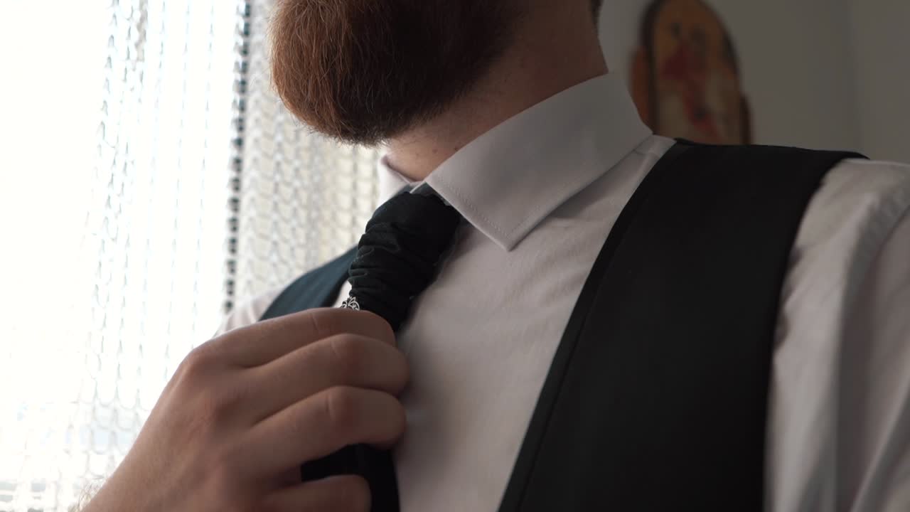 Close-up men's hands arranging a tie