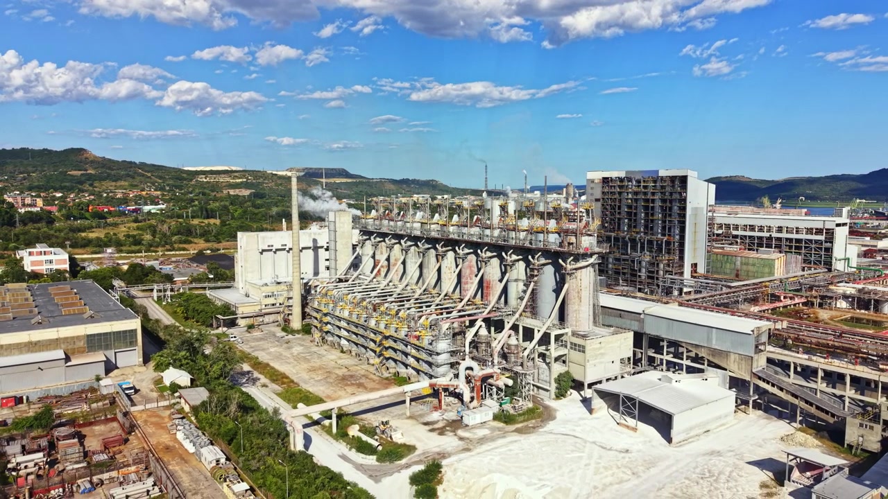 Factory in an industrial area during daytime with clear sky and clouds